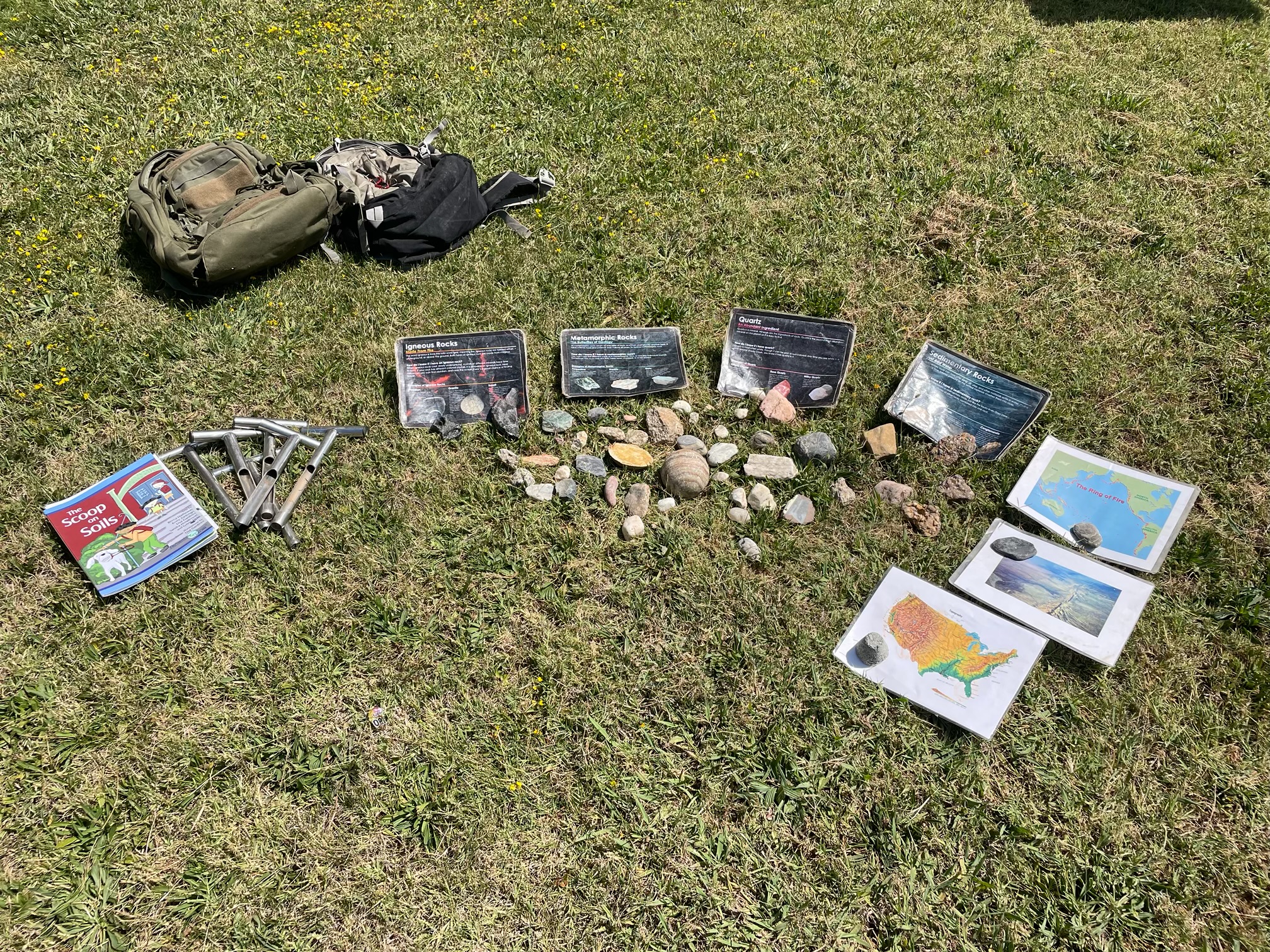 resources for learning about soils and geology -- including soil augers, Elementary GLOBE soils storybook, and maps -- are arranged on the ground